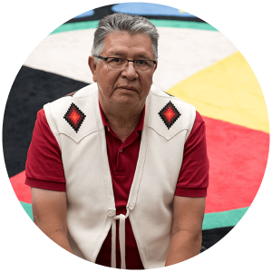 Randy sits on a medicine wheel carpet in a Calgary agency