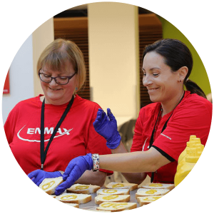 Enmax employees smile while volunteering to make sandwiches for Calgarians in need.