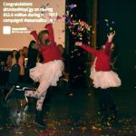 Two girls play with confetti at a local event.