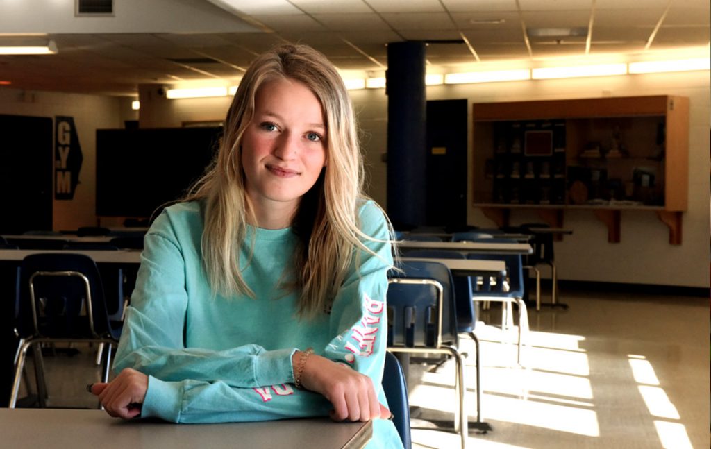A photo of Bryanna sitting in a school classroom.