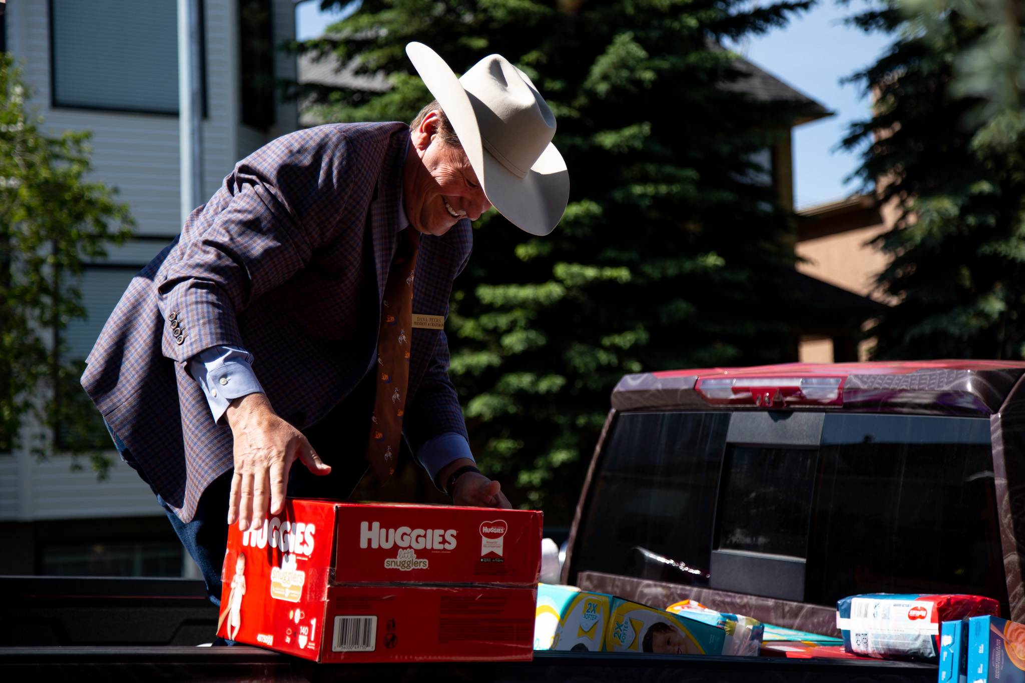 Stampede official smiling and loading a box of diapers into the back of the truck