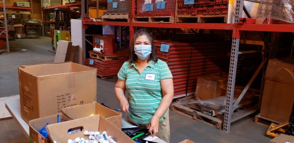 Women working in a warehouse wearing a face mask